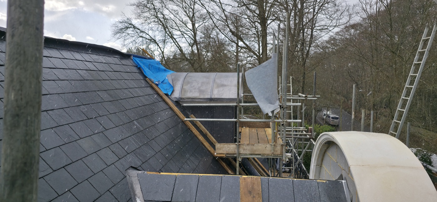 Slate roof replacement in progress with scaffolding