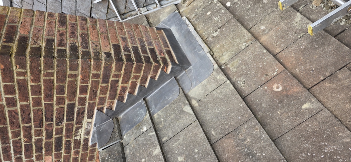 Lead step flashing at roof hip on clay tile