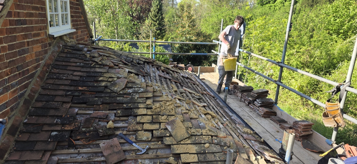 Crew stripping old roof on period property
