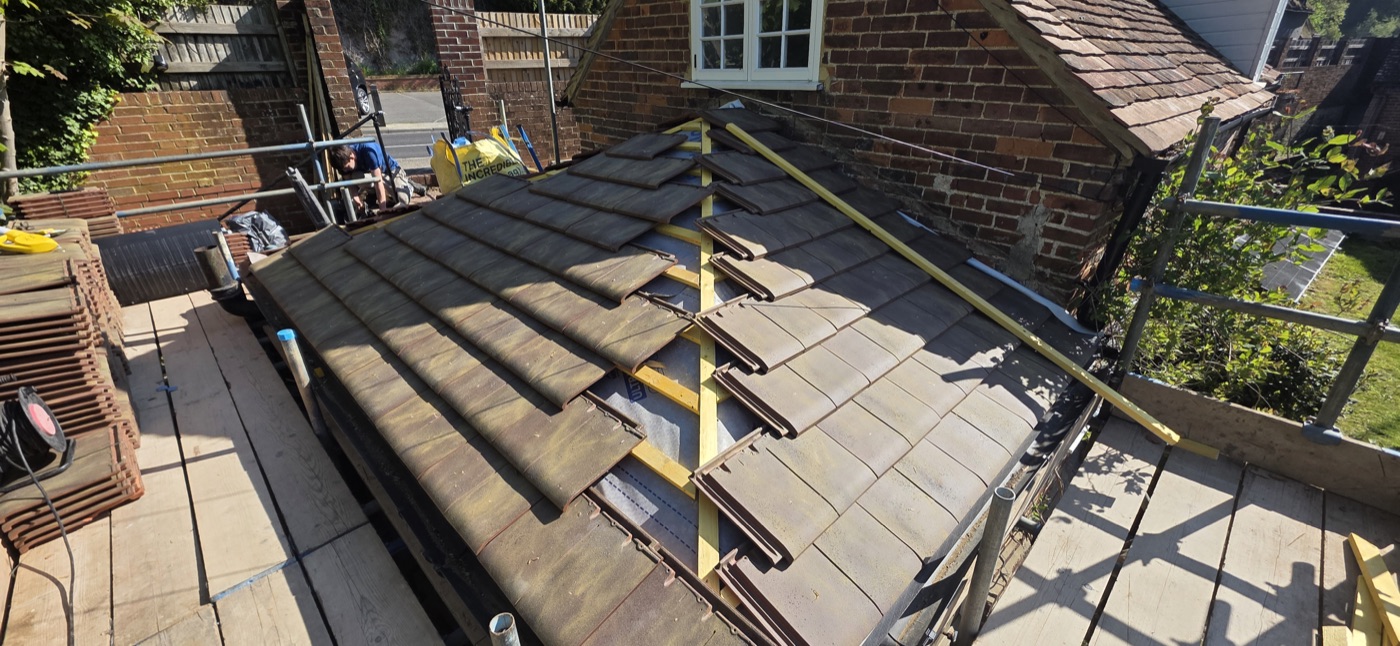 Concrete tile roof being laid on house extension