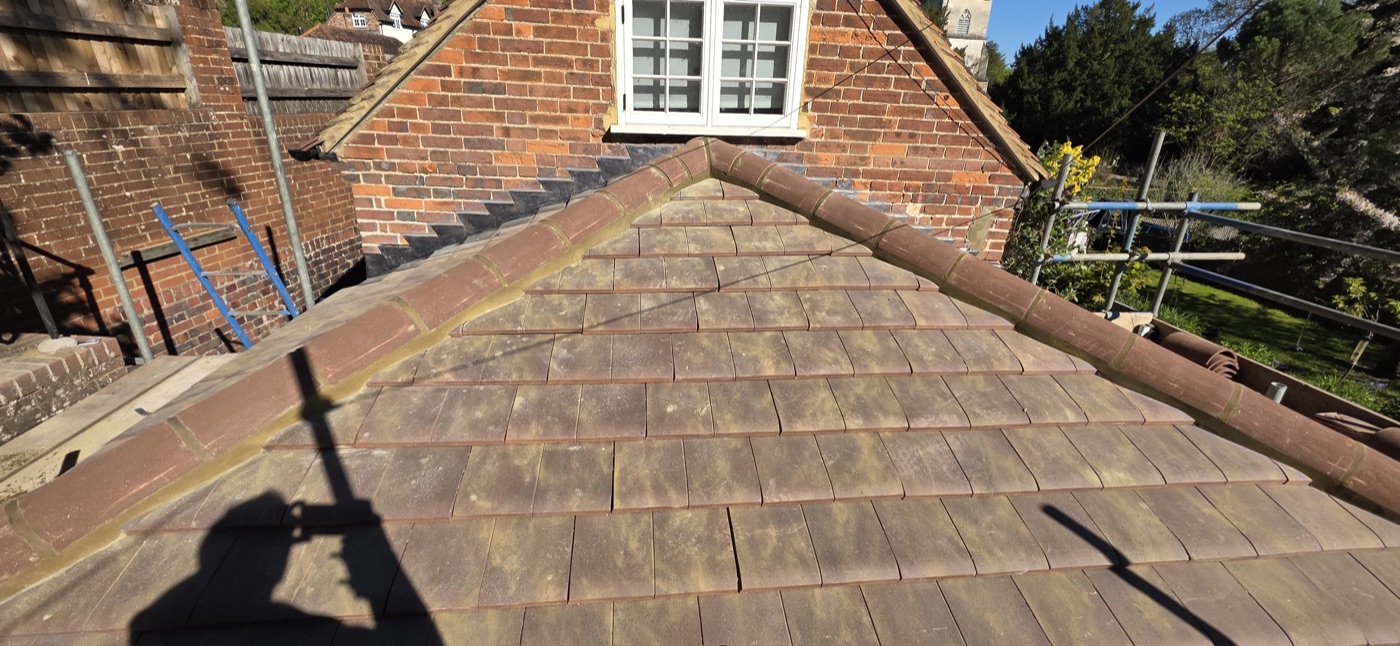Finished tile hip roof against red brick gable