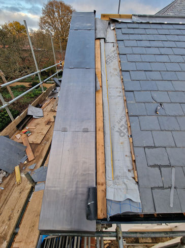 Slate roof replacement in progress on scaffolding
