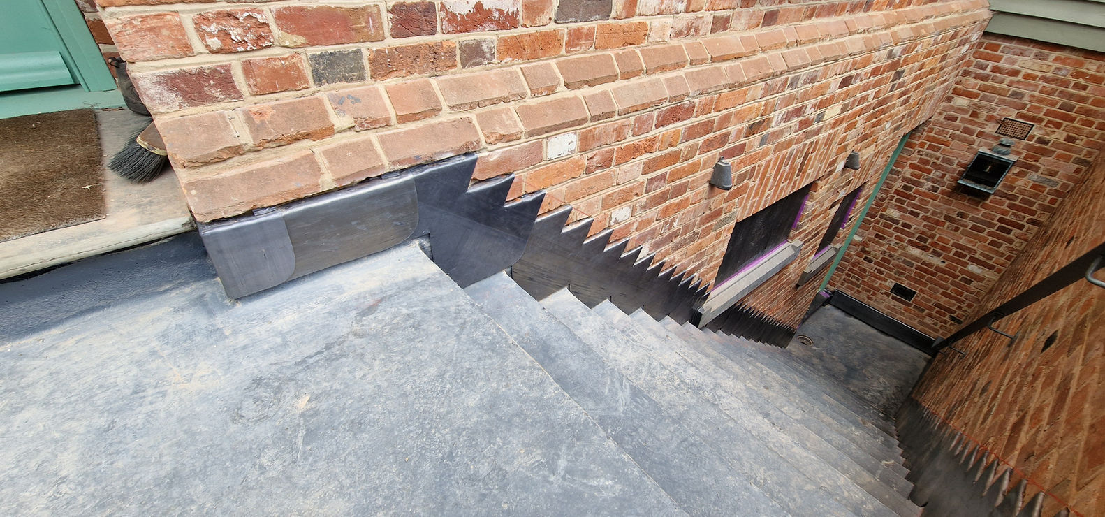 Lead flat with stepped soaker flashing on brick