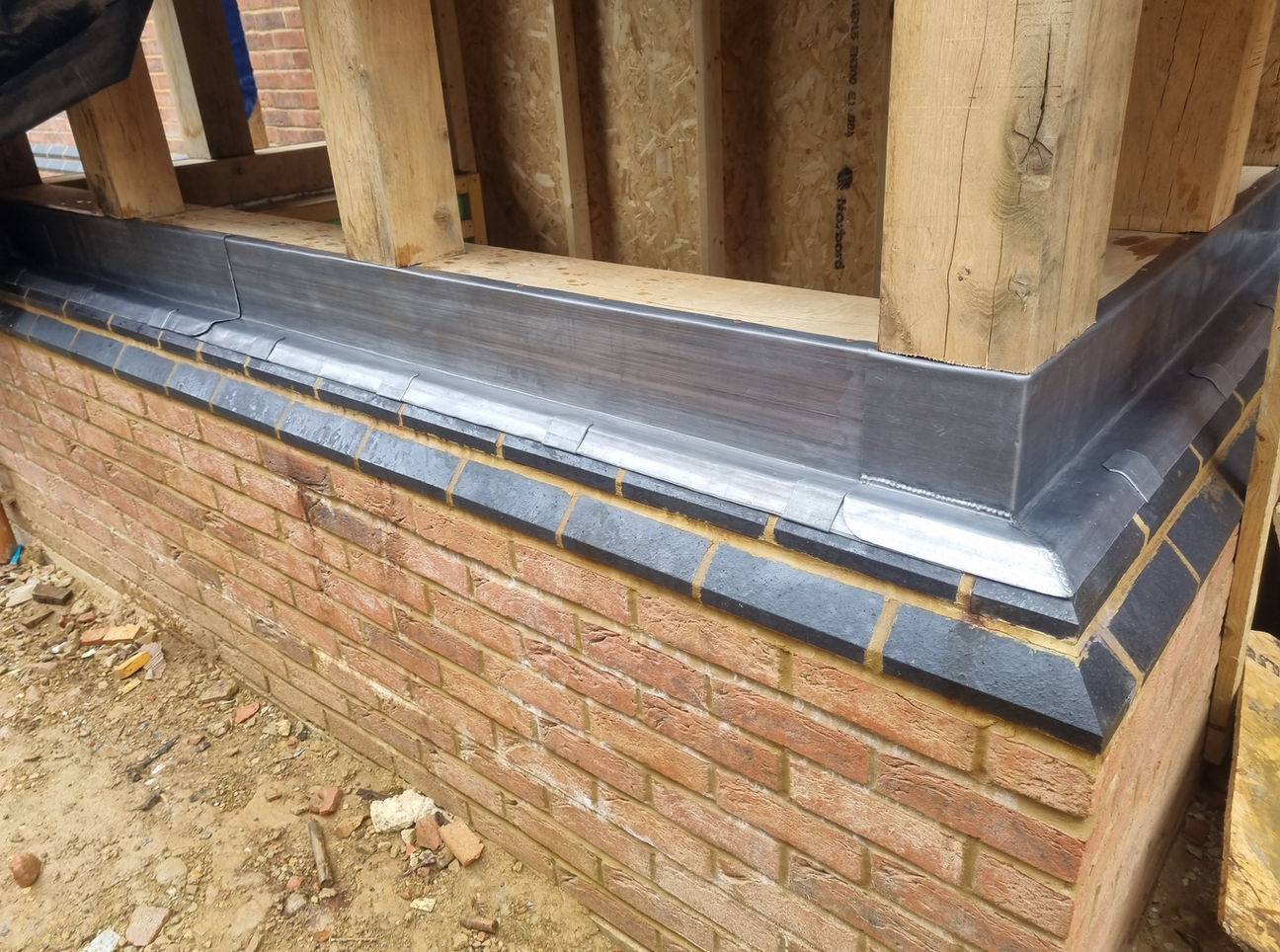 Lead coping and parapet on new brick wall