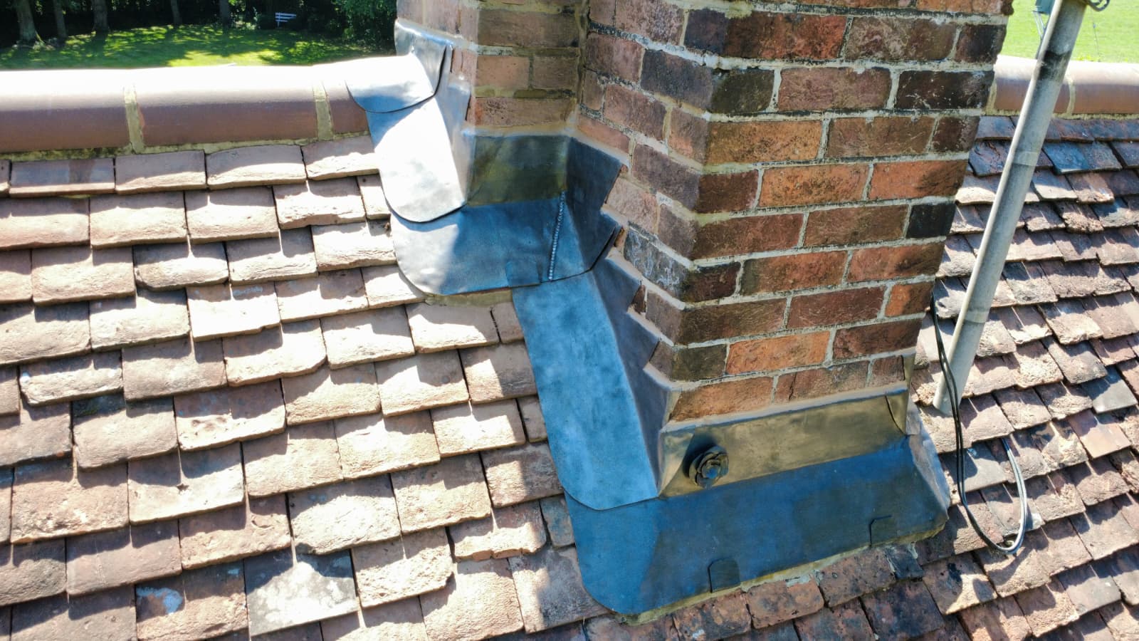 New lead apron and stepped flashings around chimney on clay tile roof