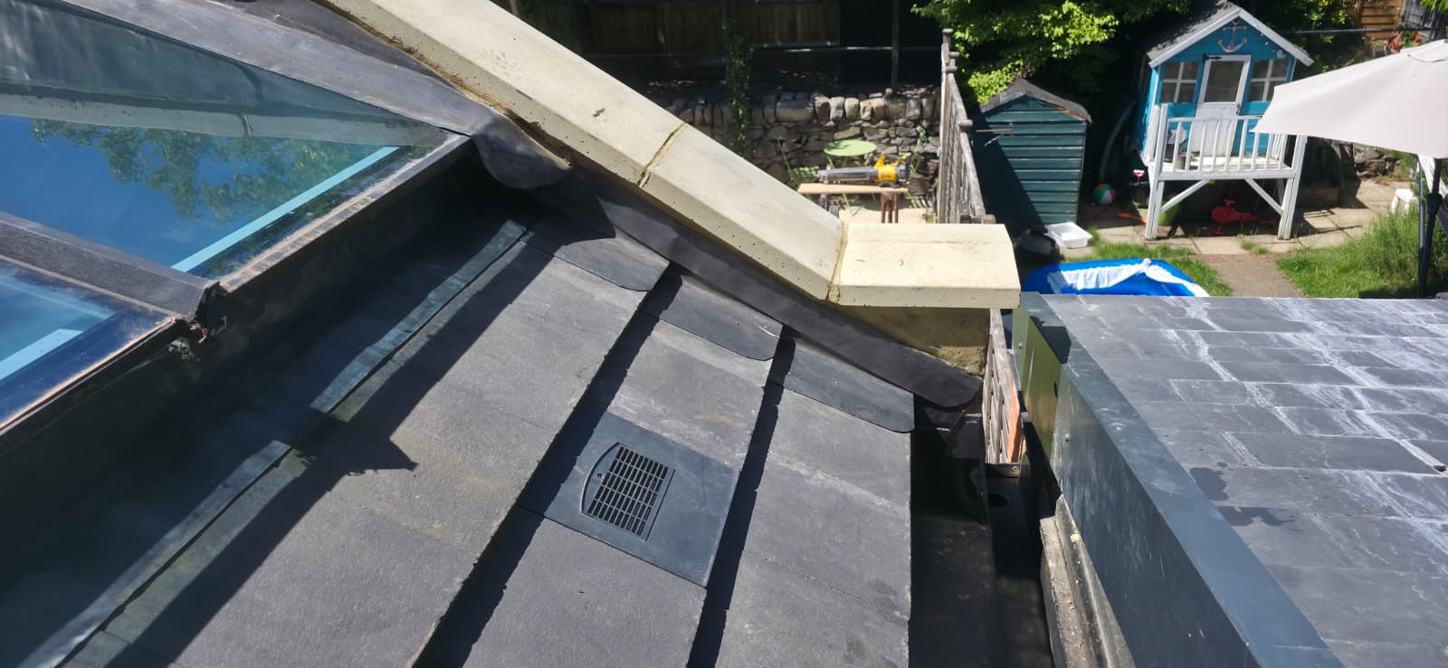 New slate roof beside glass lantern with lead soakers and coping